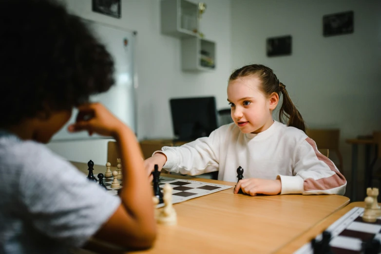 a girl and a boy are sitting at a table