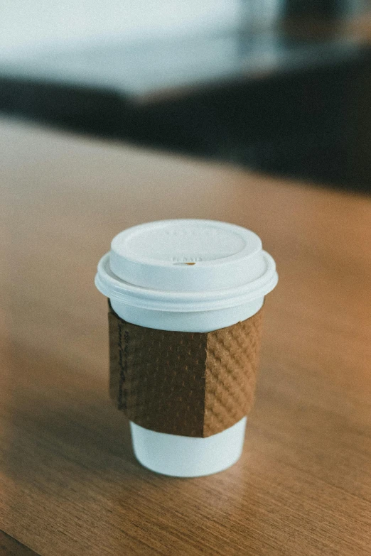 a coffee cup sitting on a table with a blurry background
