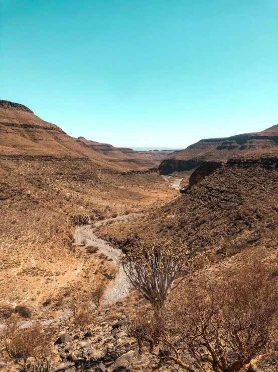 the view looking down at some brown and grassy hills