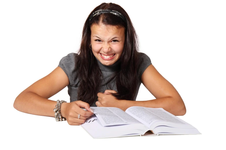 a smiling girl holds an open book with the pages on it