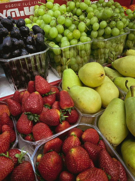 different fruits are on sale in containers and fruit bowls