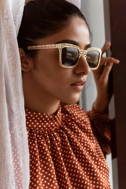 a woman in a polka dot shirt with sunglasses