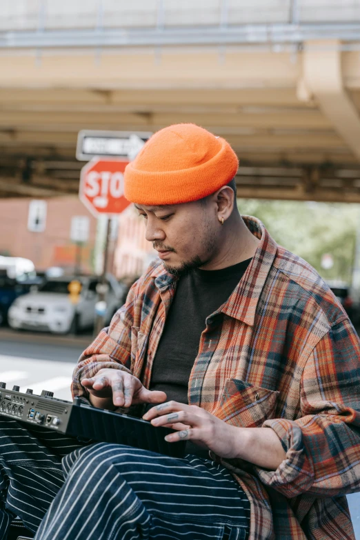 the young man is sitting on a bench while playing an electronic device