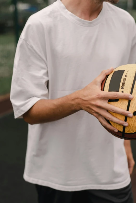 a man holding a yellow and black soccer ball