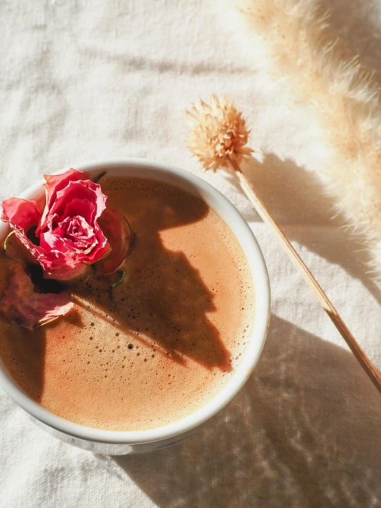 there is a small bowl with liquid and flowers in it