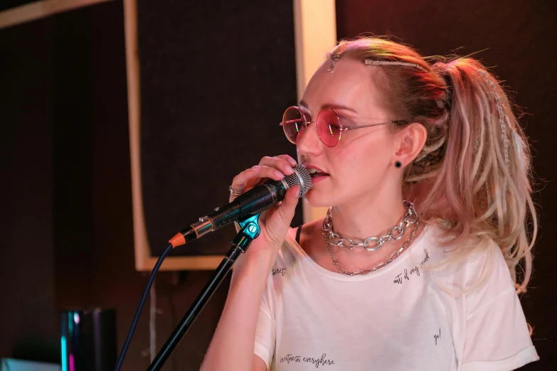 a woman in sunglasses holds a microphone to her mouth