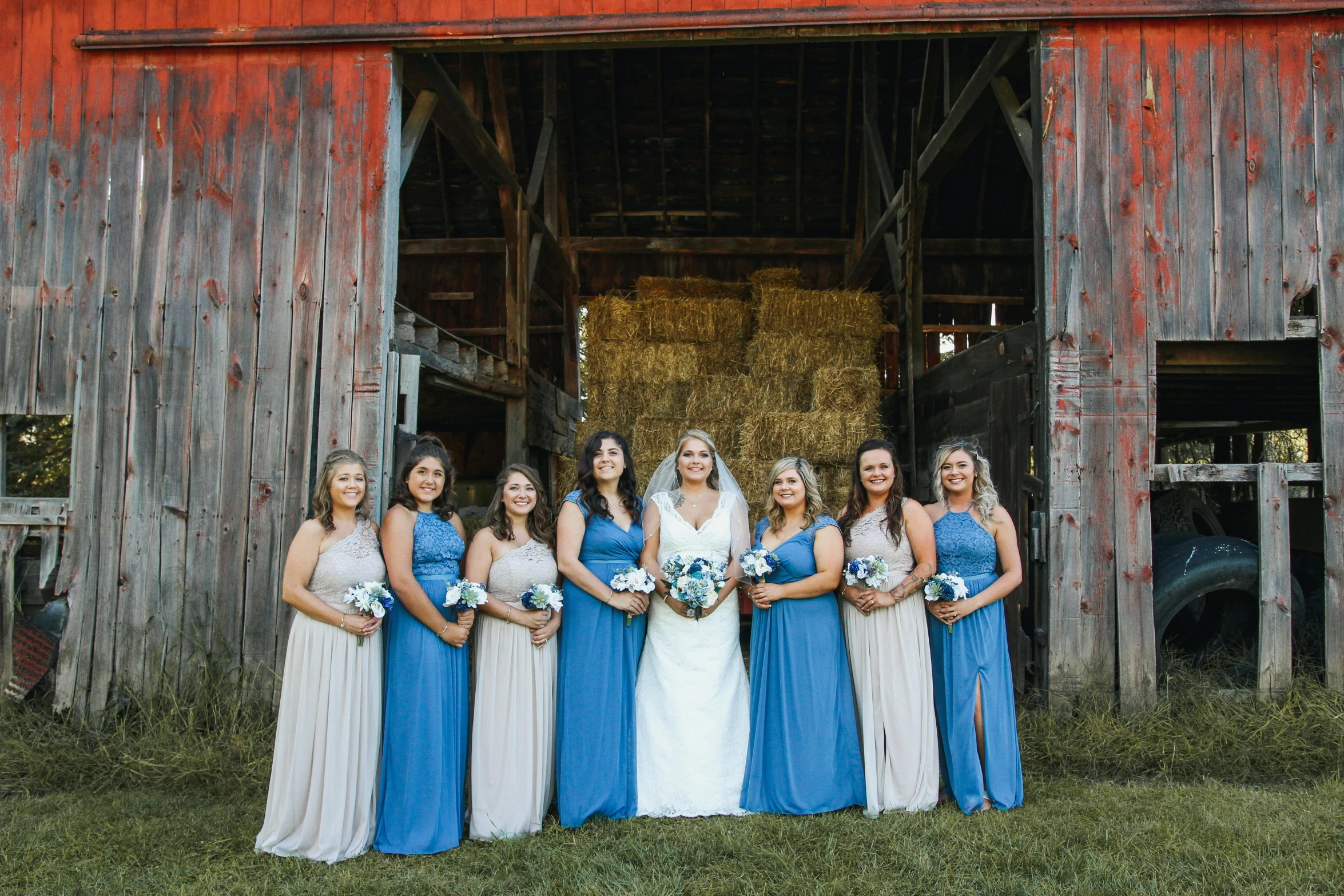 a bunch of women standing outside of a barn