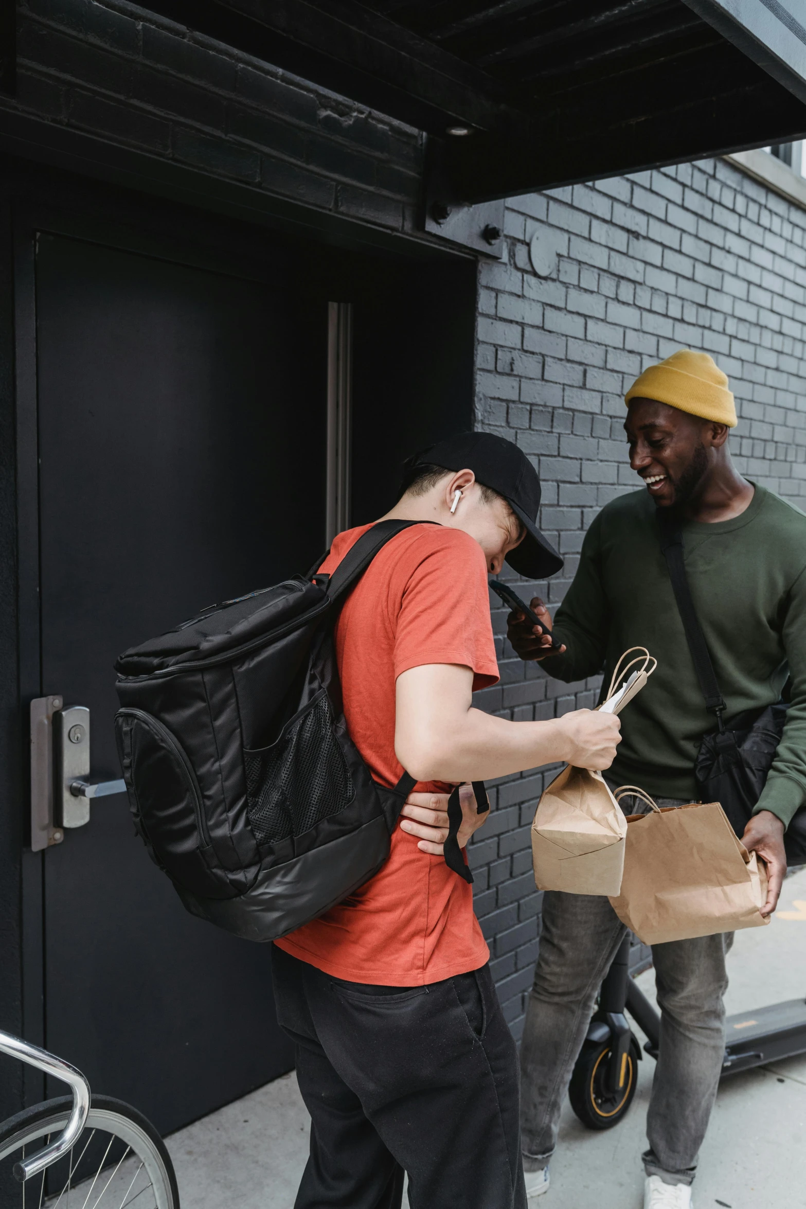 two people with backpacks near a doorway and a man