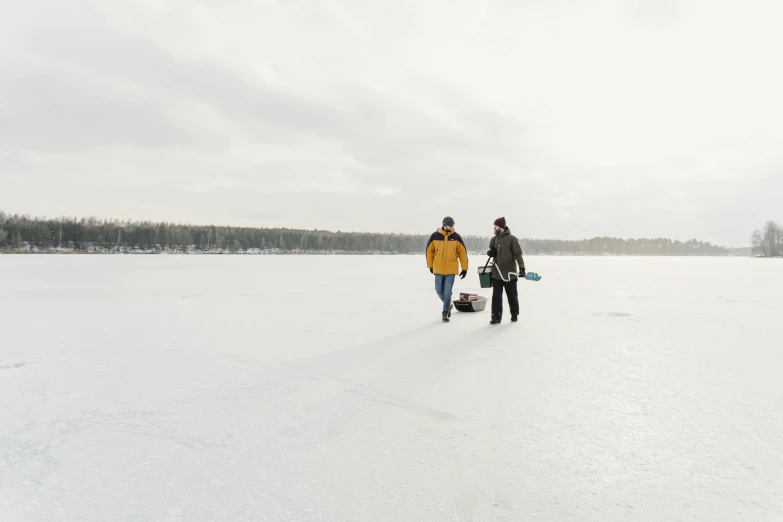 a couple are walking through the snow carrying snowboards