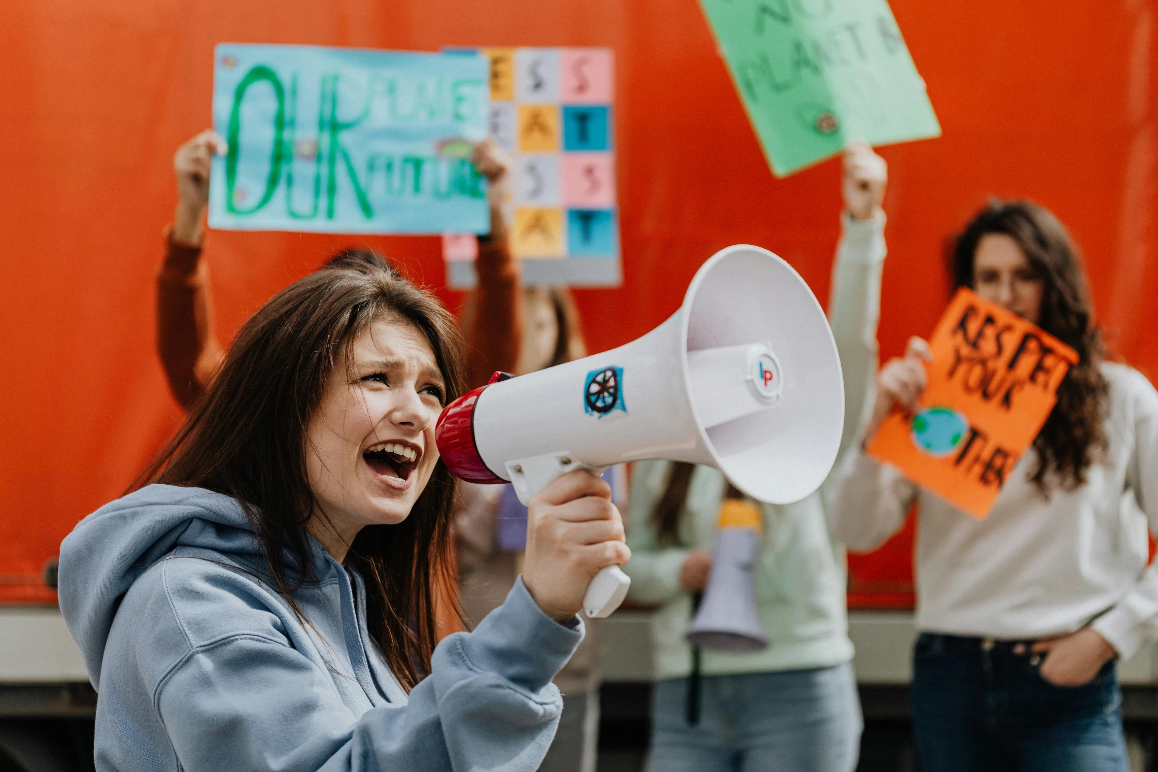 a woman speaking into a megaphone in front of a crowd