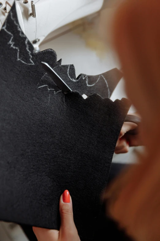 a woman is stitching fabric with scissors