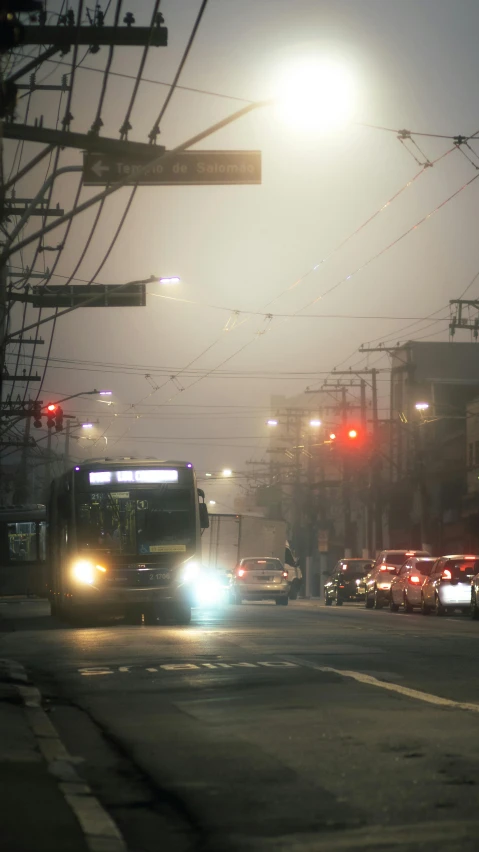 cars and buses are driving along the street