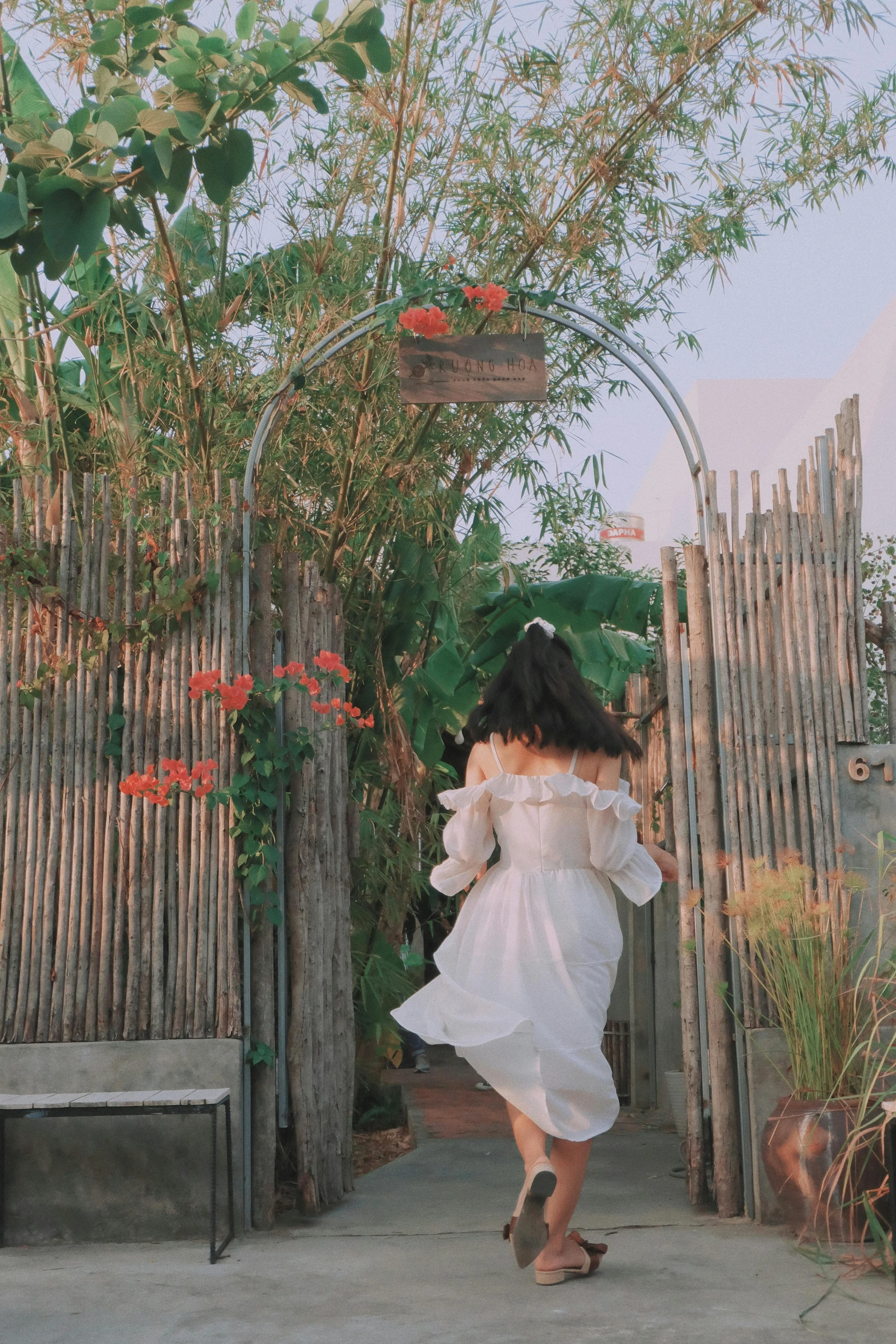 a woman walks through a small village covered in bamboo