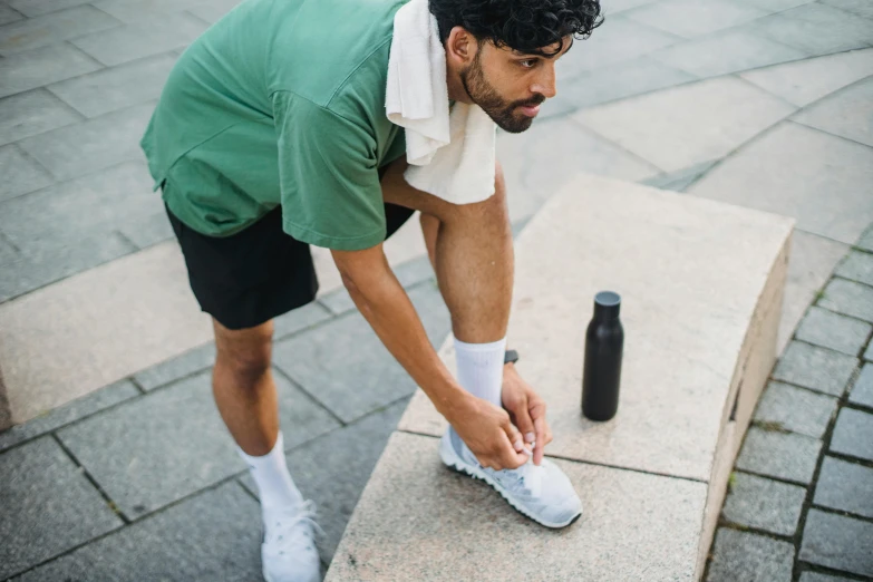 a man with curly hair is tying up a pair of shoes