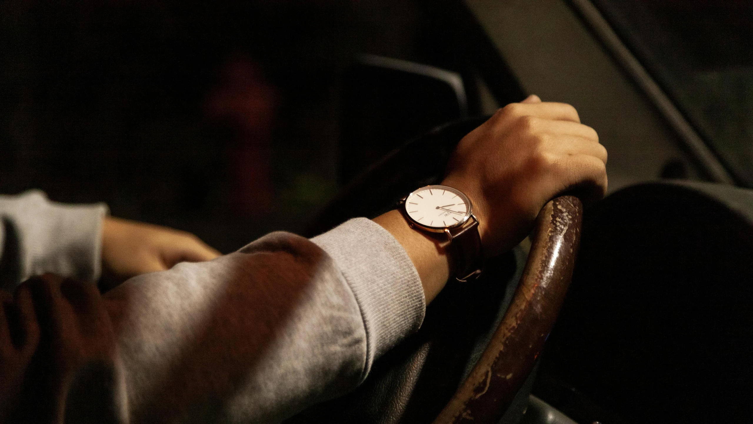 a person with a watch on their hand while driving a car