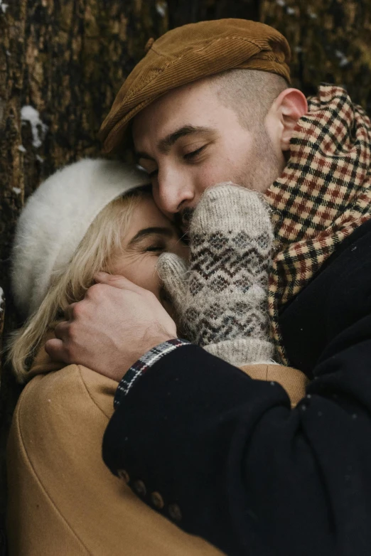 a man and woman emce together outside in the snow