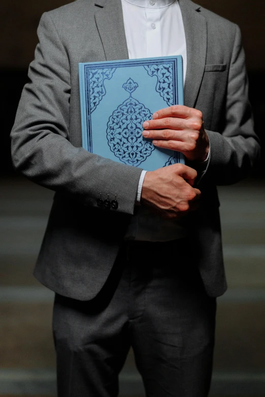 a man is holding a book open and wearing a tie