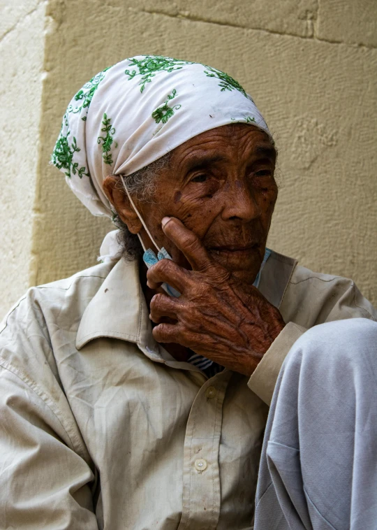 an old woman on the phone wearing a headscarf