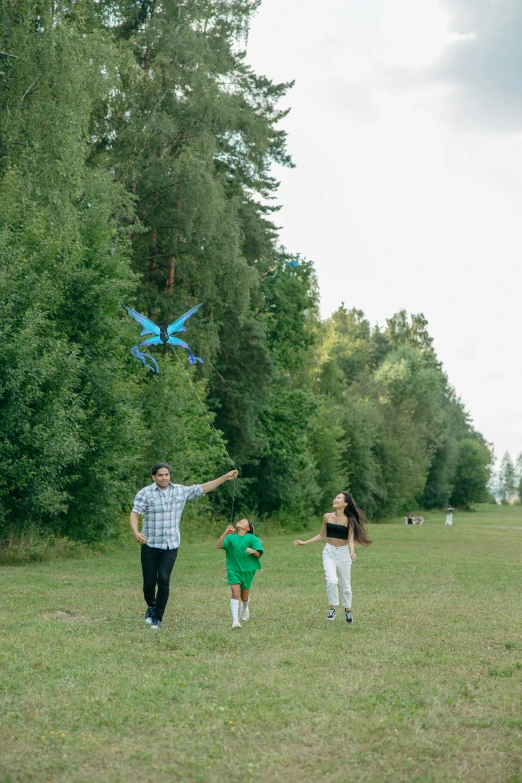 a father, mother and son in a field flying a kite