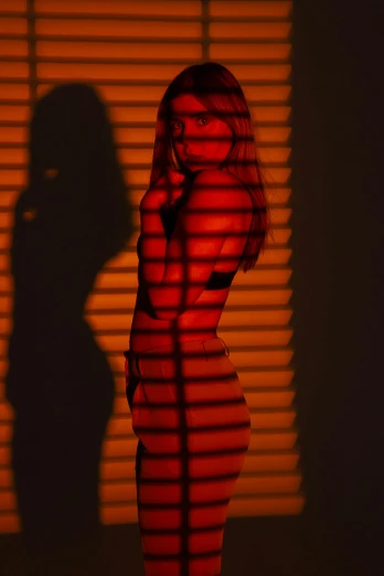 a woman standing with her head propped back and looking off to the side, in front of blinds