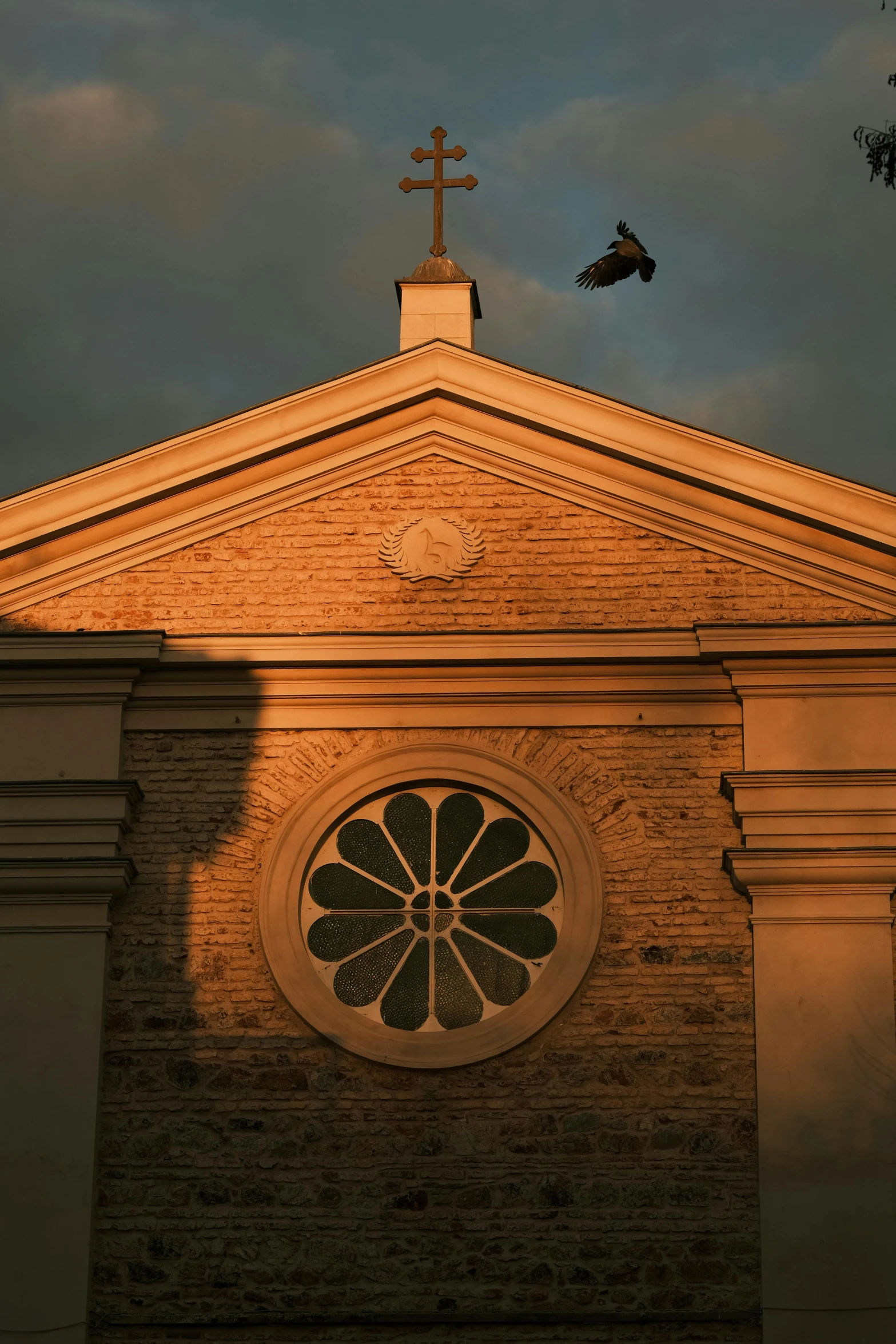 a church with a large window and a cross on top