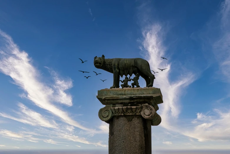 a bronze statue of a pig sitting on top of a pillar