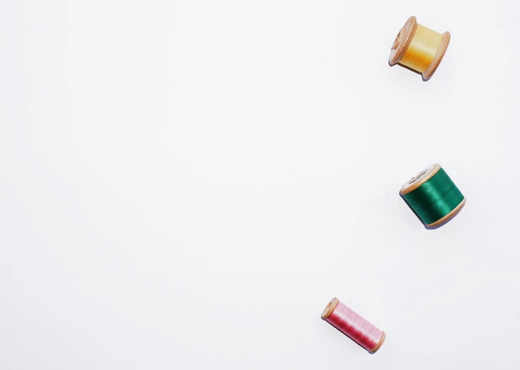 a row of spools of thread and spools of colored thread