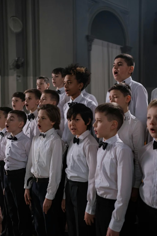 a choir of boys and girls sing in an auditorium