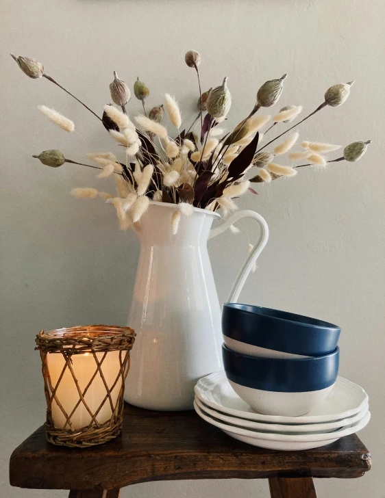 a table with plates, a vase and a candle