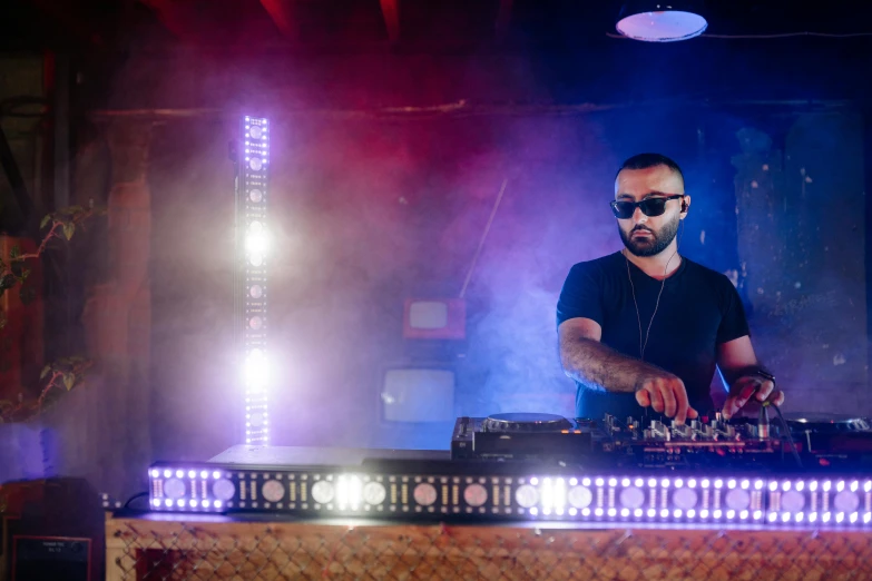 dj mixing at turn table with purple and purple lights