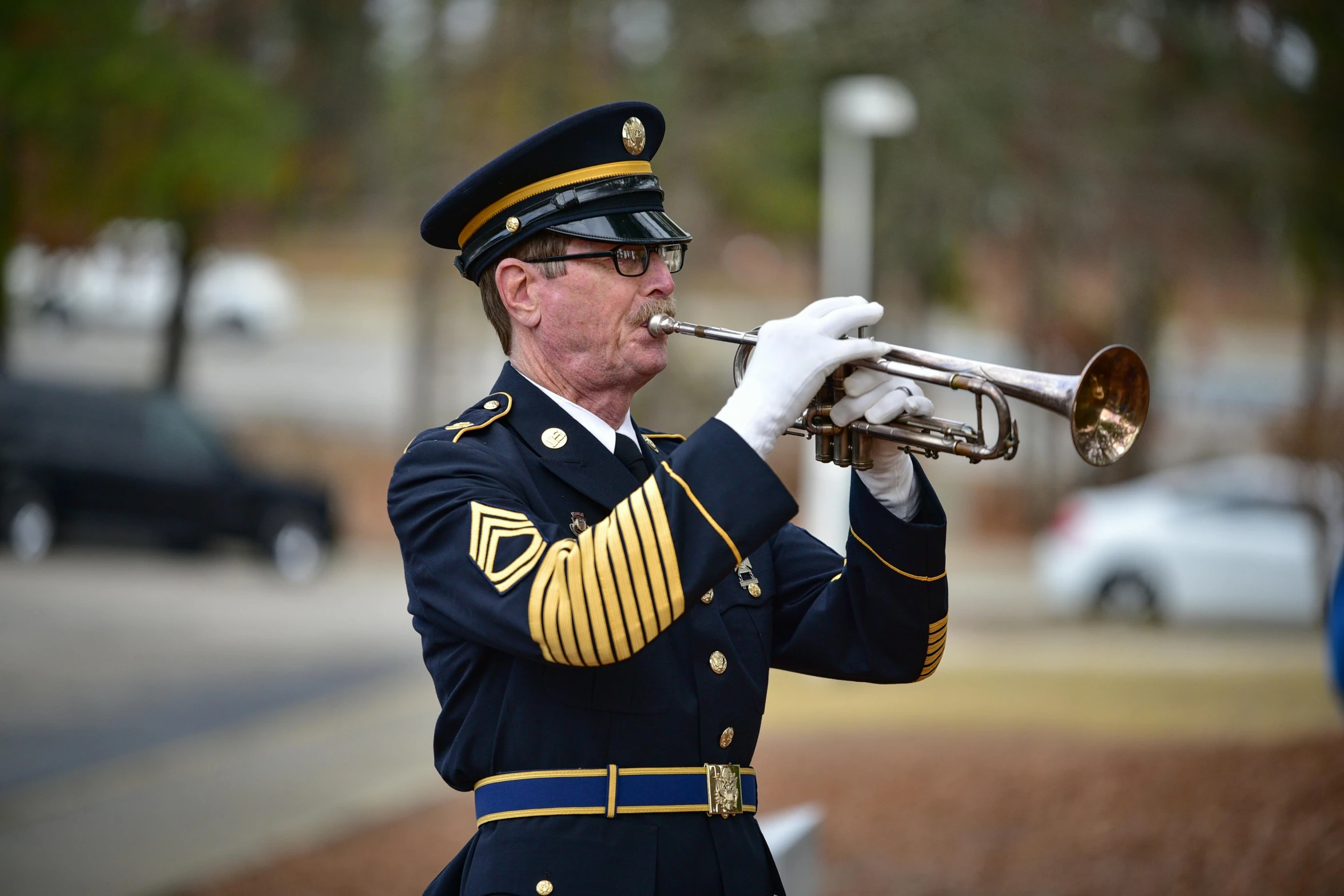 a man in military dress clothes plays a trumpet