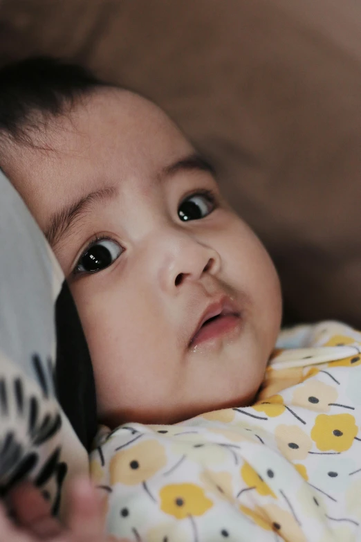 a baby is lying in bed with the blankets over his head