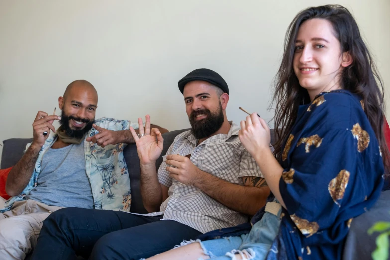 two women and one man sit on a couch