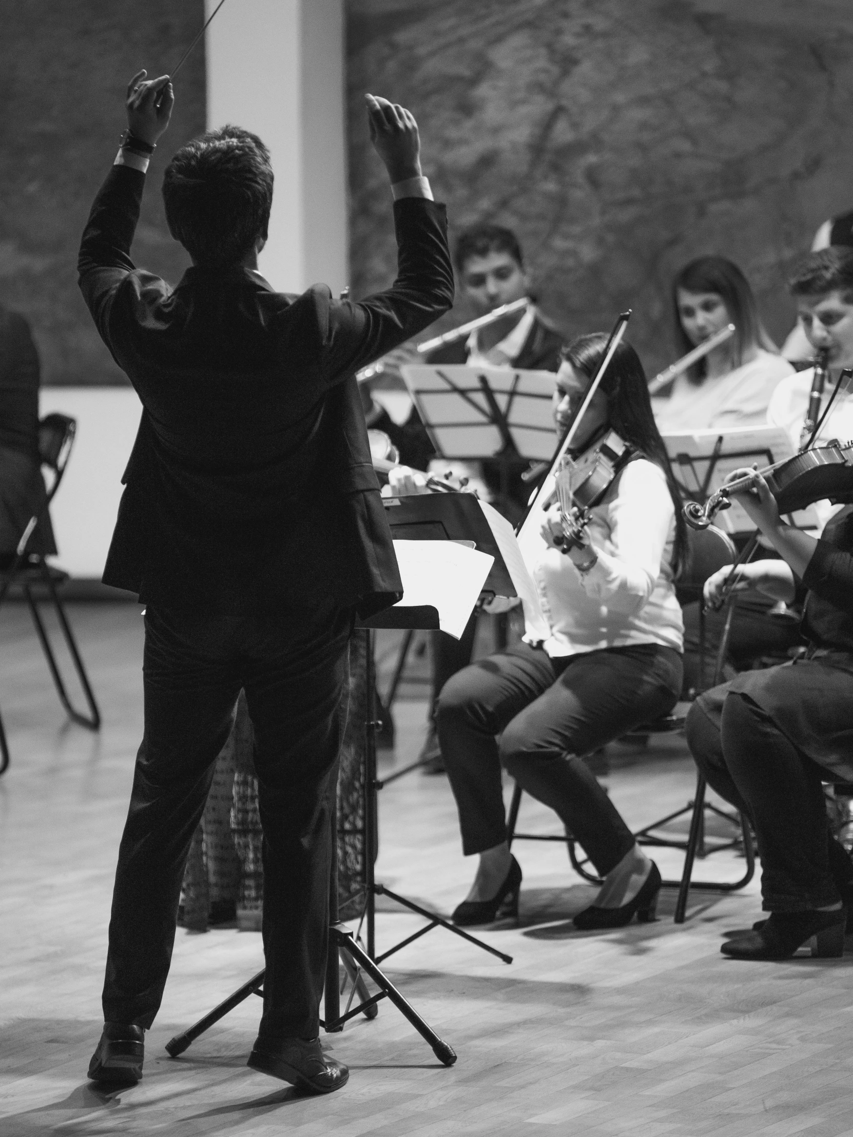 conductor directs the orchestra on an empty stage