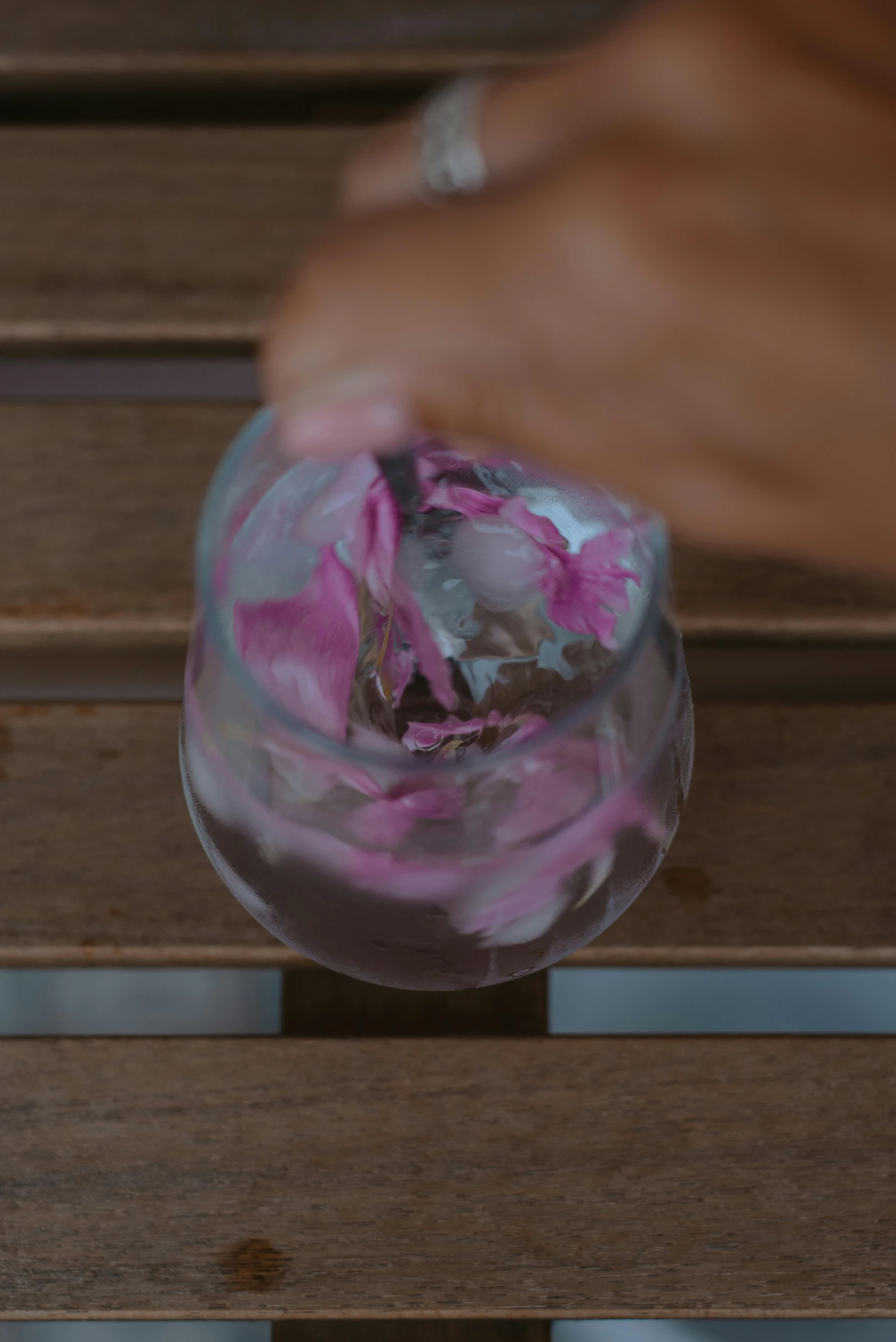 someone is arranging flowers in a vase at the top of a wooden bench