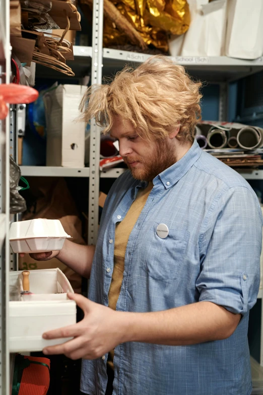 a man is looking at an item in the storage room