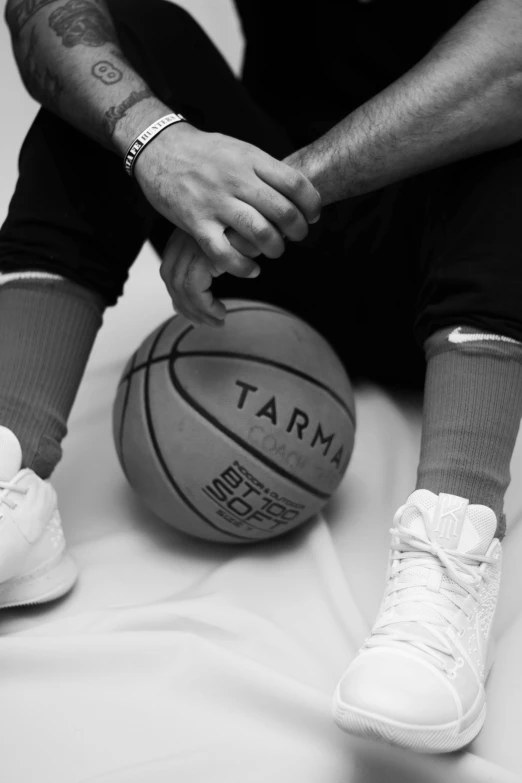 someone sitting with their feet on top of a basketball