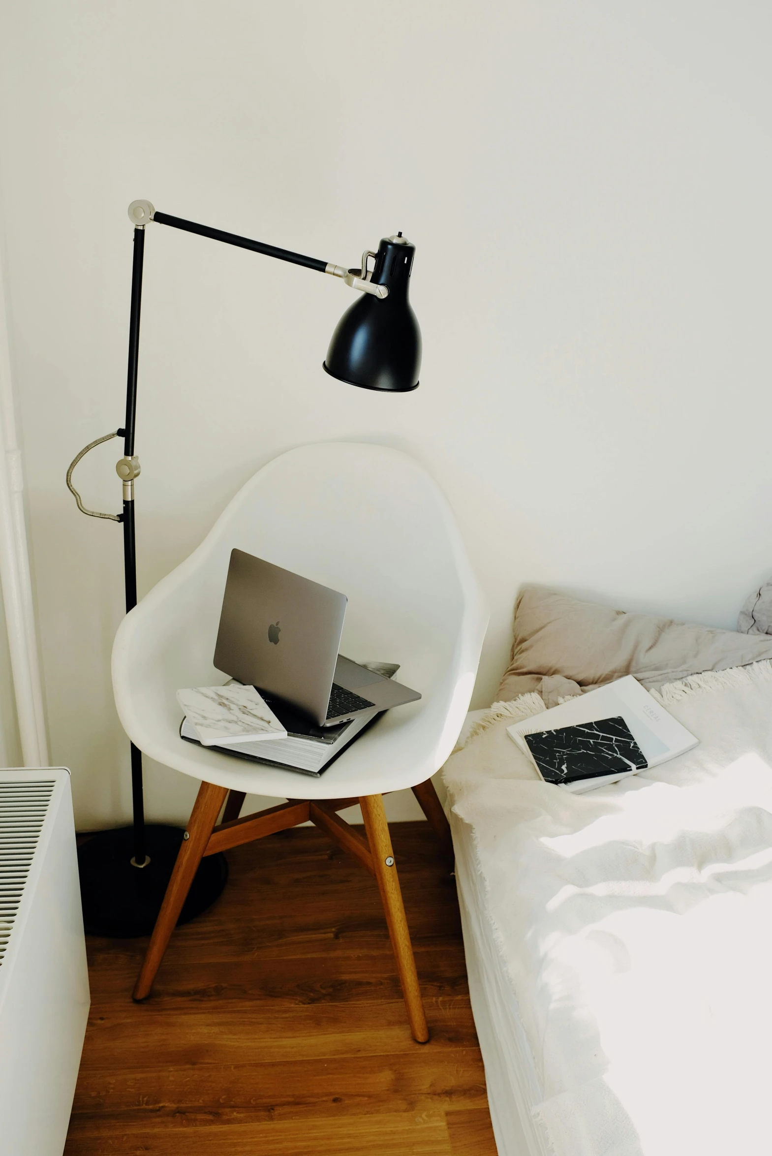 a bed with white covers and a table lamp