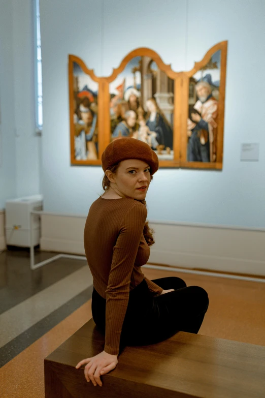 a woman sitting on the floor in front of some artwork