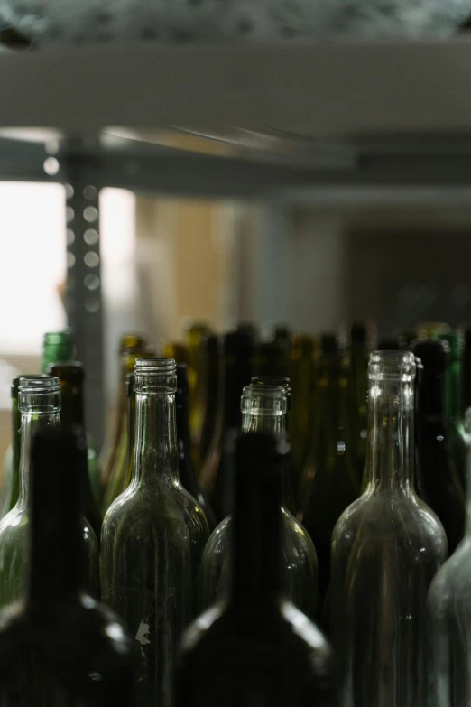 several empty and plain glass bottles stacked next to each other