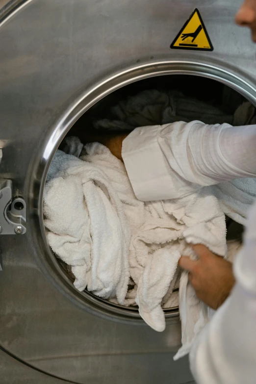 a woman doing laundry inside a washing machine