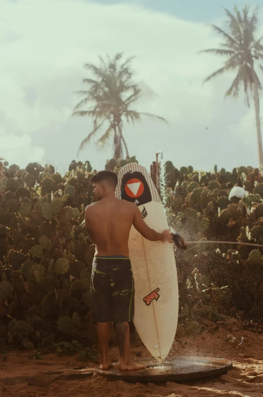 a man in black trunks carrying a surfboard