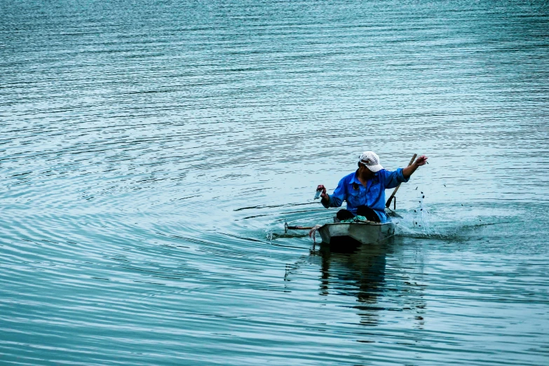 a man on a small boat in the middle of a lake