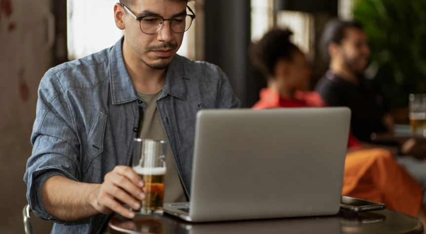 a man using a laptop computer at a bar