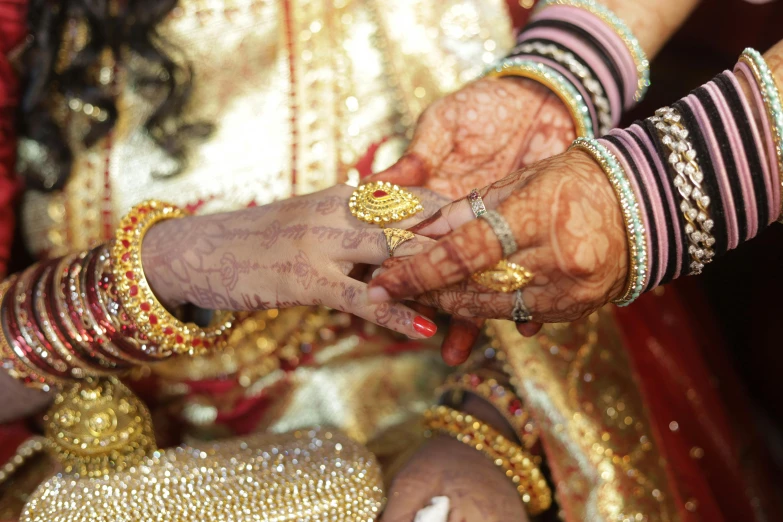 hands holding hands with rings and celets on them