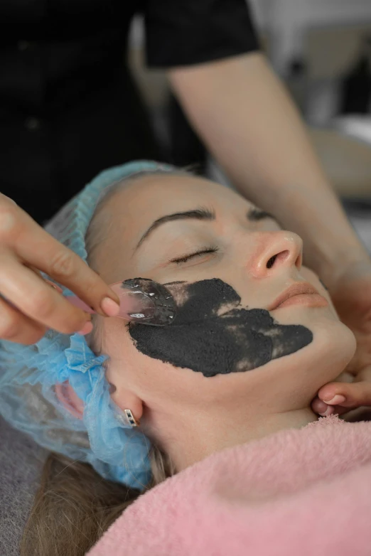the woman is getting facial care from a machine