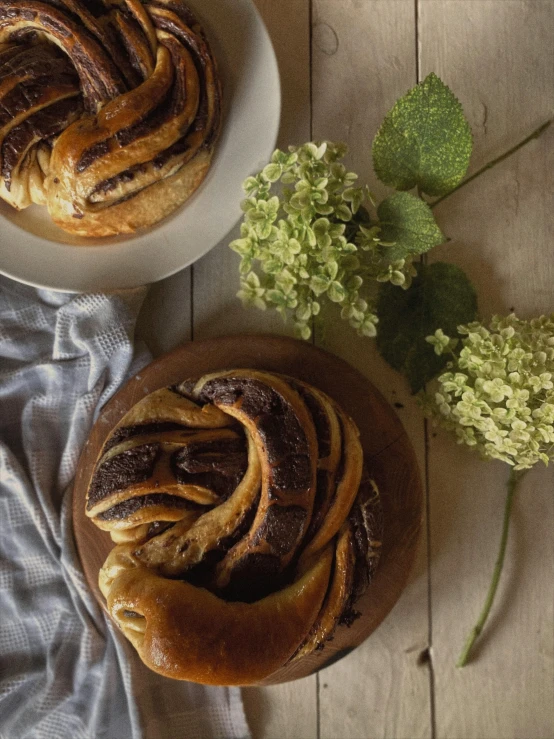 two round cake plates sitting next to a plate with a flower