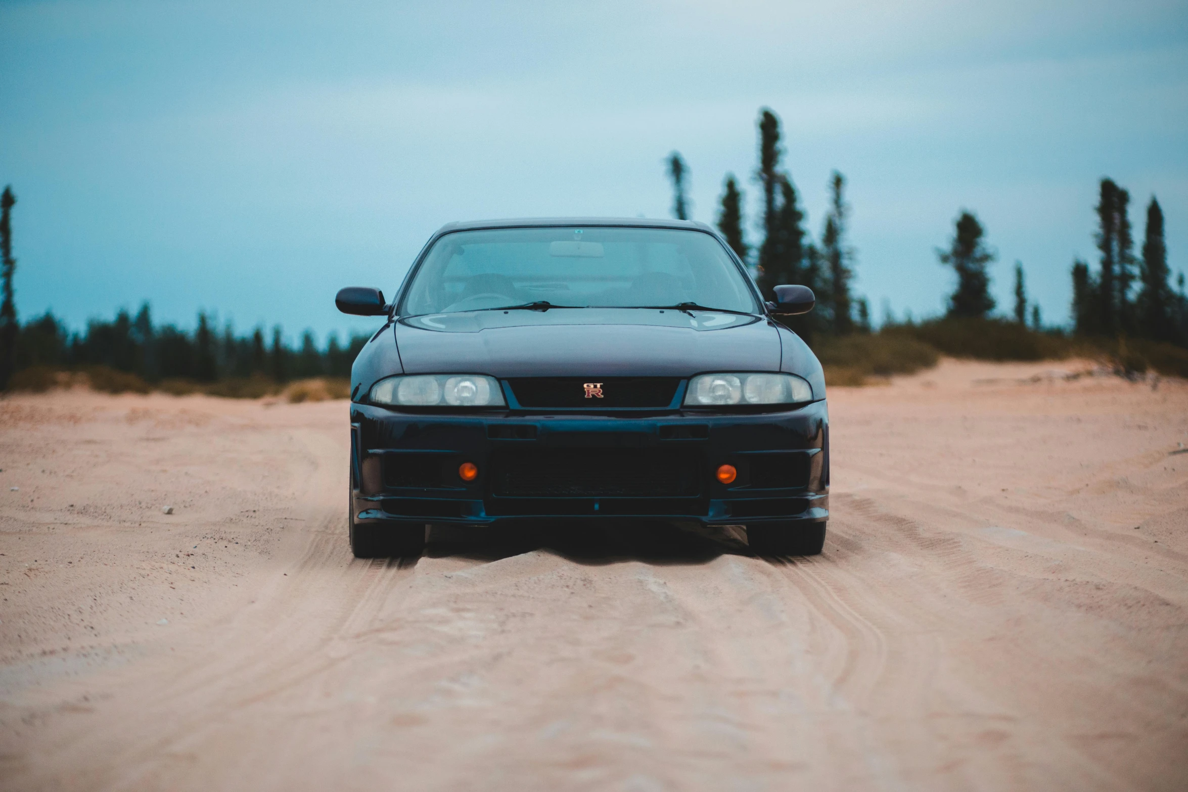 a car parked in the middle of a dirt road