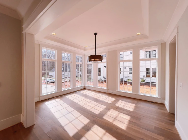 the empty room has many windows and wood floors