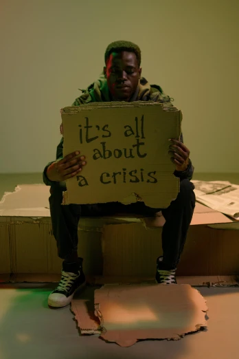 a person sitting on a chair holding a sign